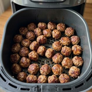 An air fryer basket of browned carnivore beef meatballs